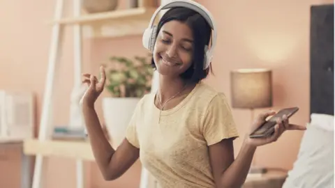 Getty Images Woman dancing with headphones