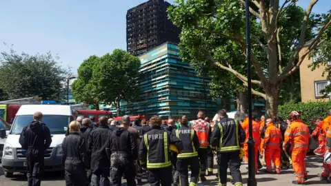 AFP Firefighters at Grenfeell Tower after a minute's silence on Monday