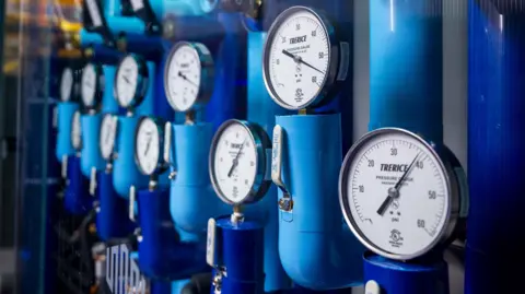 The Washington Post via Getty Images Pressure gauges attached to blue pipes at a data centre