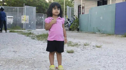 World Vision Australia  Two-year-old Roze stands on the gravel on the island of Nauru