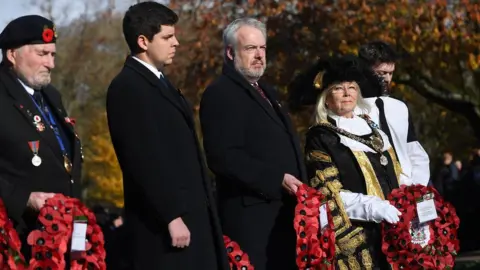 Welsh Government Carwyn Jones holding wreath at a service at the Welsh National War Memorial