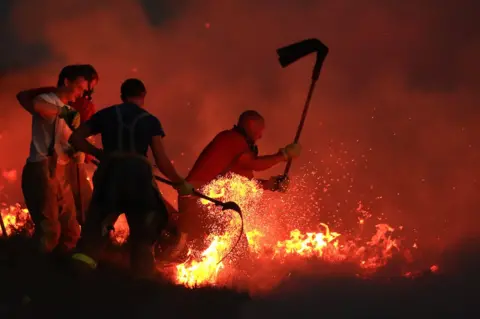 PA Fire fighters tackle a wild fire on Winter Hill near Bolton. 28 June 2018.