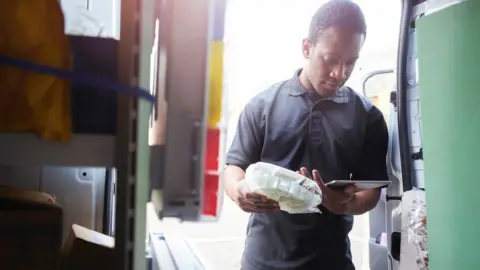 getty images Man checking stock in a van