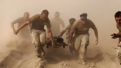 Reuters US troops pull a soldier to safety in Afghanistan, October 2010