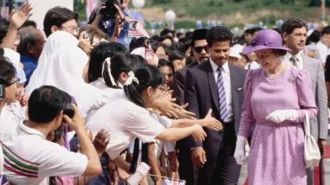 Getty Images British Royal Queen Elizabeth II, wearing a lavender print dress with a wide-brim lavender hat, in Malaysia, October 1989.