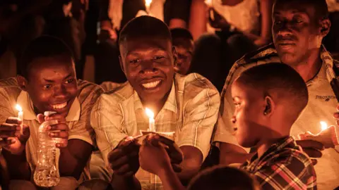 AFP Children lighting candles during a night vigil and prayer at the Amahoro Stadium in Kigali, Rwanda - Sunday 7 April 2019