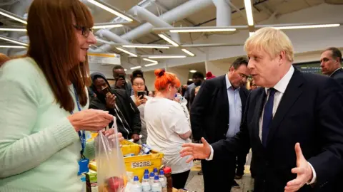 Getty Images Prime minister Boris Johnson speaks to a helper