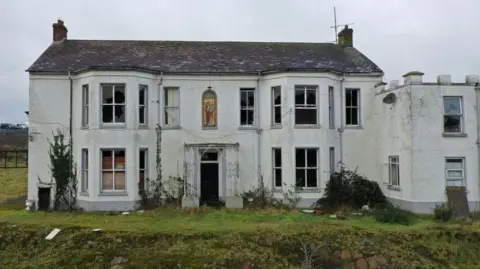 Getty Images: The mother and baby home in Marianvale from the outside. It is white, some of the windows are broken. There is a stained glass window at the front.