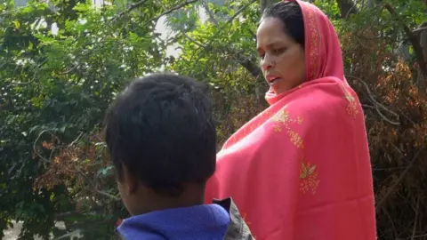 Rubaiyat Biswas/BBC Sonali Khatun looks at her son who is walking beside her.