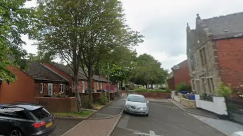 Google Bank Street in Church - A cul-de-sac with red brick buildings on the left and stone building on the right.