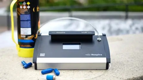 PA Media A new breathalyser device with tiny blue nitrous oxide (NOS) canisters in front of it