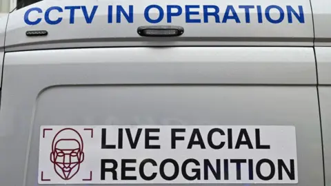 A Live Facial Recognition technology sticker on a van. The sticker also features a silhouette of a human face.