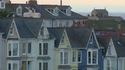 BBC Rows of properties with sea in distance