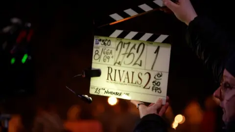 Julius Peacock/BBC A closeup of the clapper, which has 'Rivals 2' written on it, and then lots of other numbers to do with the scene and date, which says 25 November.