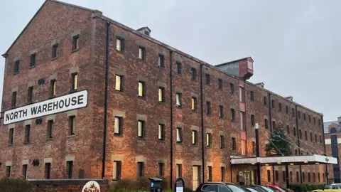 LDRS A brown brick warehouse, a council office, with lots of windows against a grey sky