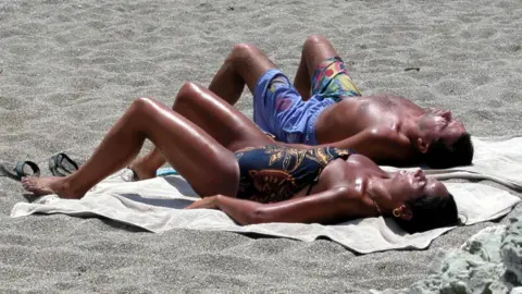 BBC Couple sunbathing on Crete beach