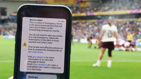 Getty Images A phone screen is seen in the foreground at the ground during the Ireland vs New Zealand Women's World Cup game in Brighton.