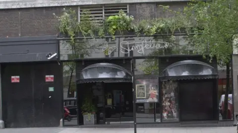 The front of Stringfellows club in Covent Garden. Grey looking building with Stringfellows sign