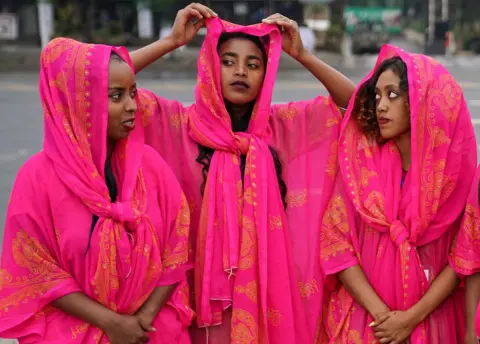 Getty Images Three women dressed in traditional dresses of the Harari culture of eastern Ethiopia .