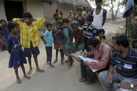 AFP via Getty Images An Indian census worker (2nd R) gathers data at a village in Lalgarh, some 130 kms west of Kolkata