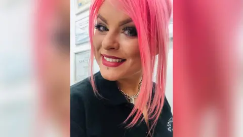 Charmaine Shinner A woman looking at the camera and smiling. There are certificates on the wall behind her.