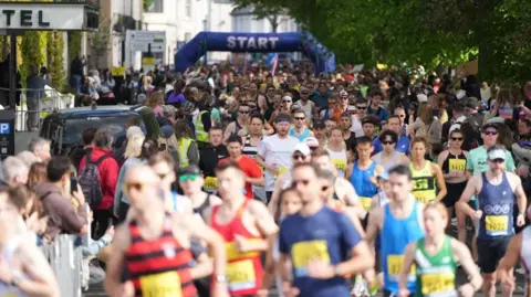 Runners pictured during the Worthing Half Marathon 2025, just after starting the race. The start line can be seen in the image.