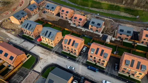 Getty Images Aerial view of a construction site of residential houses, with plots and roads partially completed 