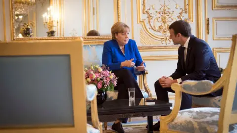 Getty Images German Chancellor Angela Merkel and the French President Emmanuel Macron speak at the beginning of the Franco-German Council of Ministers at the Elysee Palace