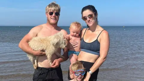 Family handout Katy Hancock with her husband Ed and children Dylan and Taylor at a beach