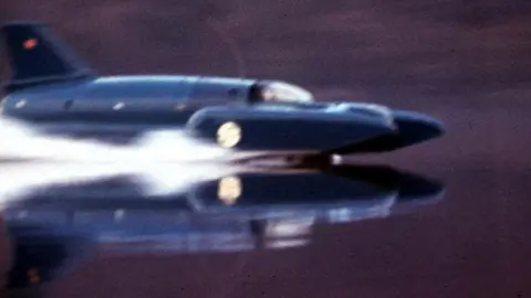 PA Media The original Bluebird speeds across a lake