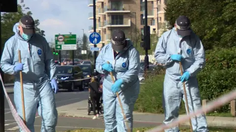 Forensic officers searching near the scene where Sabina Nessa was found