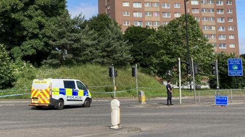 A police van parked close to a block of flats