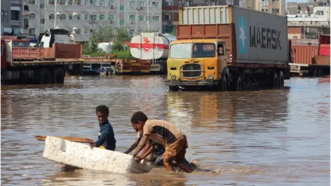 AFP Children push a makeshift raft in a flooded street in Aden (22/04/20)