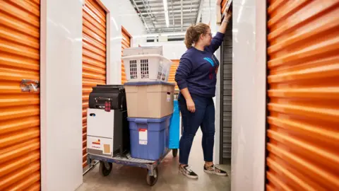 Getty Images A woman pulls up the door of a self-storage locker