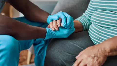 Getty Images Carer supporting person