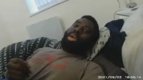 Valdo Calocane being restrained on a bed in his flat by police during a section 135 warrant under the mental health act in September 2021. The image has been taken from police body-worn camera footage dated 3 September 2021.