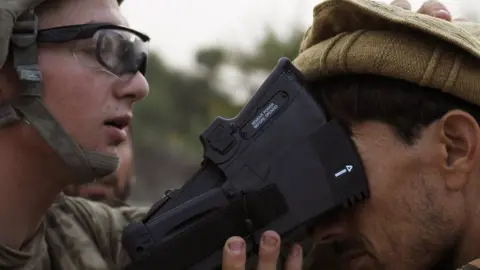 Getty Images A US solider collects biometric information from a villager