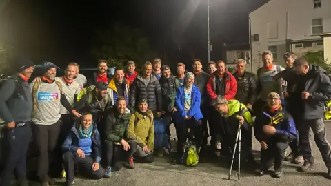 BBC The team setting off on the hike