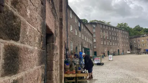 A view which gives a close up of the block work construction of Cromford Mills and the wide open area which is home to a number of craft businesses. 