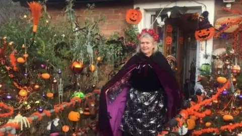 Lynda Starkey in front of her Halloween-decorated home