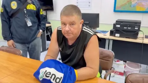 Australian man sitting at a table in a police station in Thailand