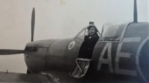 Candy Adkins Fuzzy black and white image of Jackie Moggridge sitting in the cockpit of a Spitfire