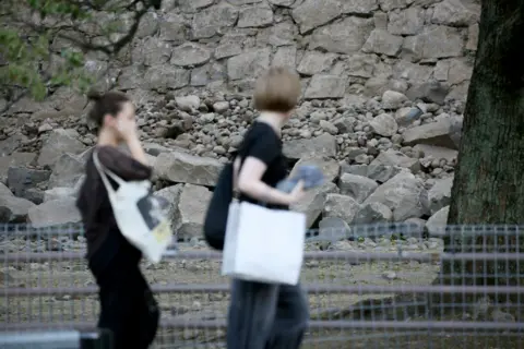 EPA People walk near the stone walls of Kumamoto Castle, which collapsed following a powerful earthquake in Kumamoto City, Japan, 28 July 2026. 