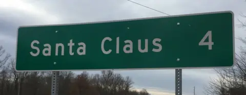 Santa Claus four miles away road sign