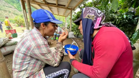 Simon Echavarria Workers at the Santa Isabel estate share a meal on 20 Nov 2020.