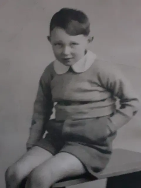 DAGCAS A black and white photo of a young boy