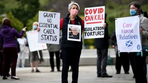 Getty Images Relatives stage a demonstration over care home coronavirus visiting rules outside the Scottish Parliament on September 16, 2020 in Edinburgh, Scotland. Families gathered outside parliament to lobby MSPs, Care Home Relatives Scotland group wants to see more access for relatives in care homes to improve the quality of life for residents.