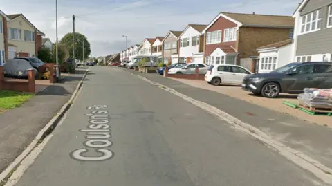 A Google Streetview of Coulsons Road, Whitchurch. Houses and cars can be seen on the left and right of a suburban street