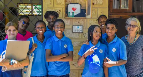 The Oliver King Foundation Pupils wearing blue t-shirts stand with staff at the Kivukoni International School in Kenya