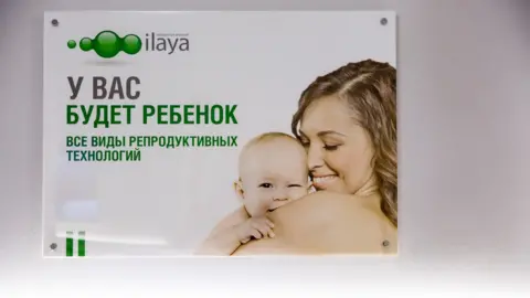 BBC An advert on the wall at the Ilaya clinic shows a woman holding a baby